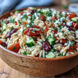 Tender orzo pasta salad, served warm with fresh herbs and briny olives.