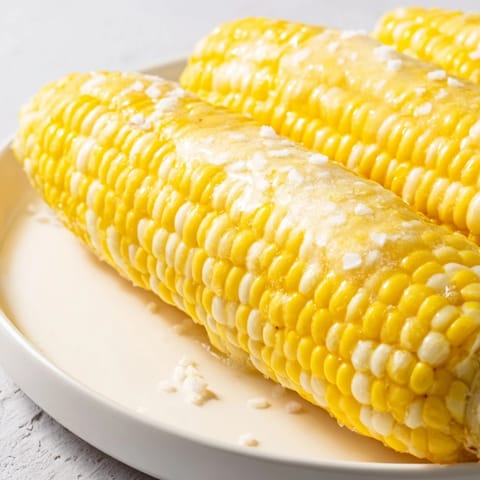 Steaming hot corn on the cob, a grilled beauty ready to be slathered in butter, a summer delight.