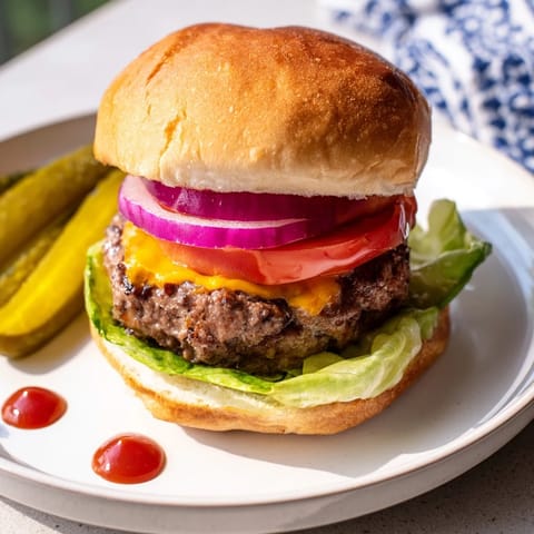 A close-up of juicy hamburgers ready to eat, featuring melted cheese and a drizzle of condiments.