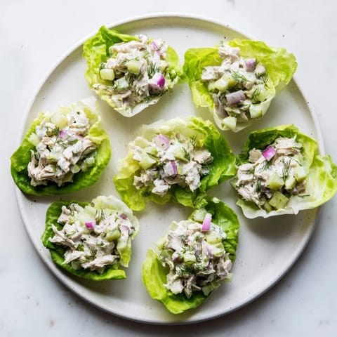 Juicy shredded chicken, crisp chopped pickles, and fresh dill tossed in creamy dressing, served in butter lettuce cups for a refreshing low-carb meal.  