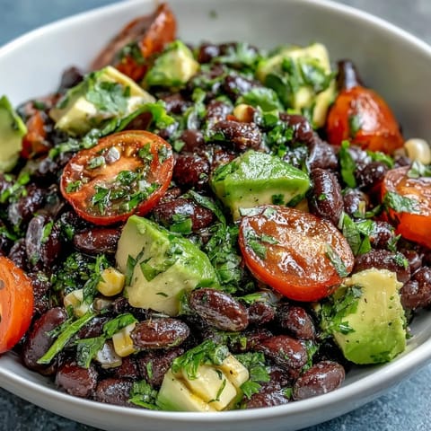 A colorful Black Bean and Veggie Bowl topped with cilantro and pumpkin seeds, perfect for a healthy vegan lunch.