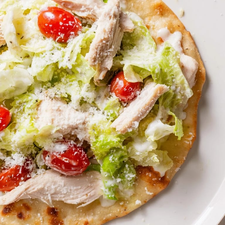 Golden-baked Chicken Caesar Flatbread with tender grilled chicken, romaine, and creamy Caesar sauce ready to slice and share.