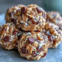 Easy No-Bake Oat Bites with Peanut Butter in a white bowl, showing golden oats and mini chocolate chips mixed with creamy peanut butter.