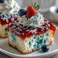 Festive Memorial Day Red White Blue Poke Cake with creamy whipped topping.